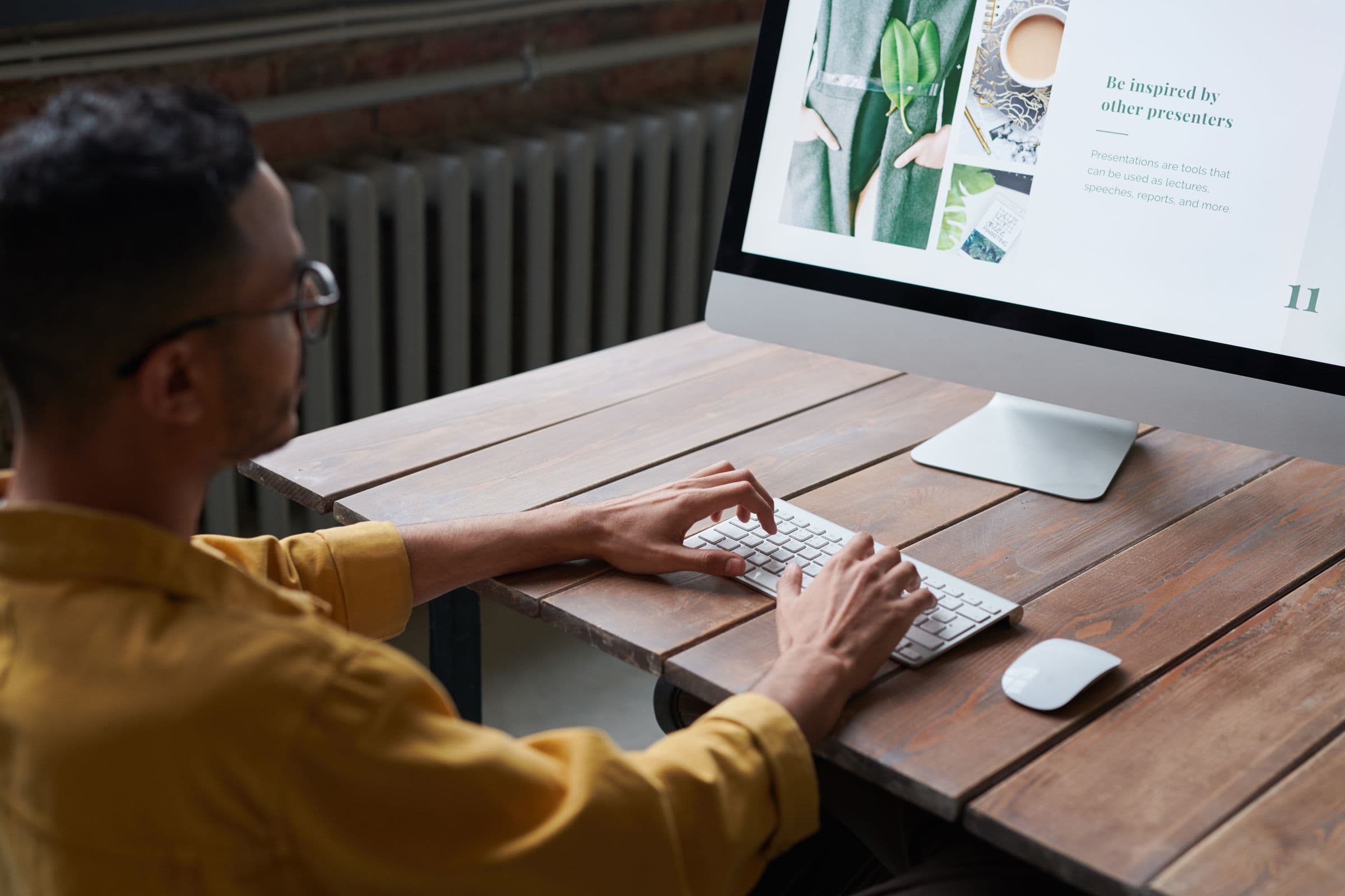 A person typing at a computer with a website open on screen